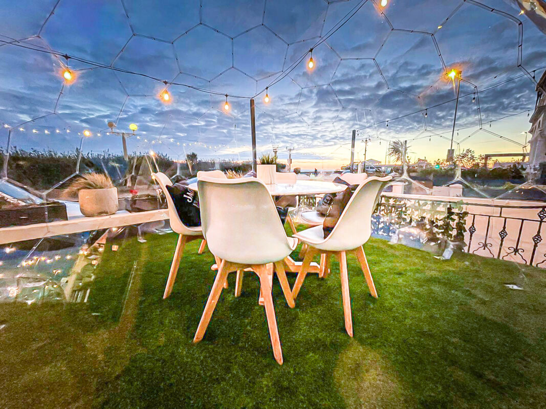 Table set in a dining pod against the cloudy sky