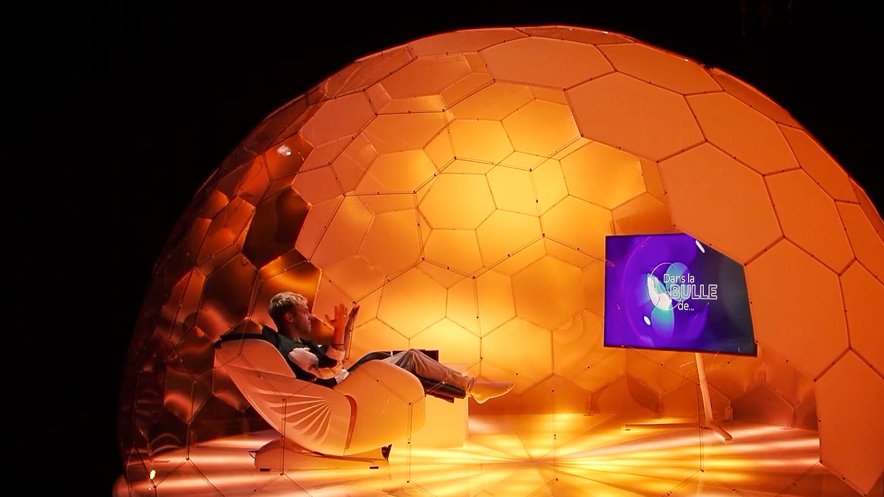 A man sitting in the Hypedome interview pod in a TV show