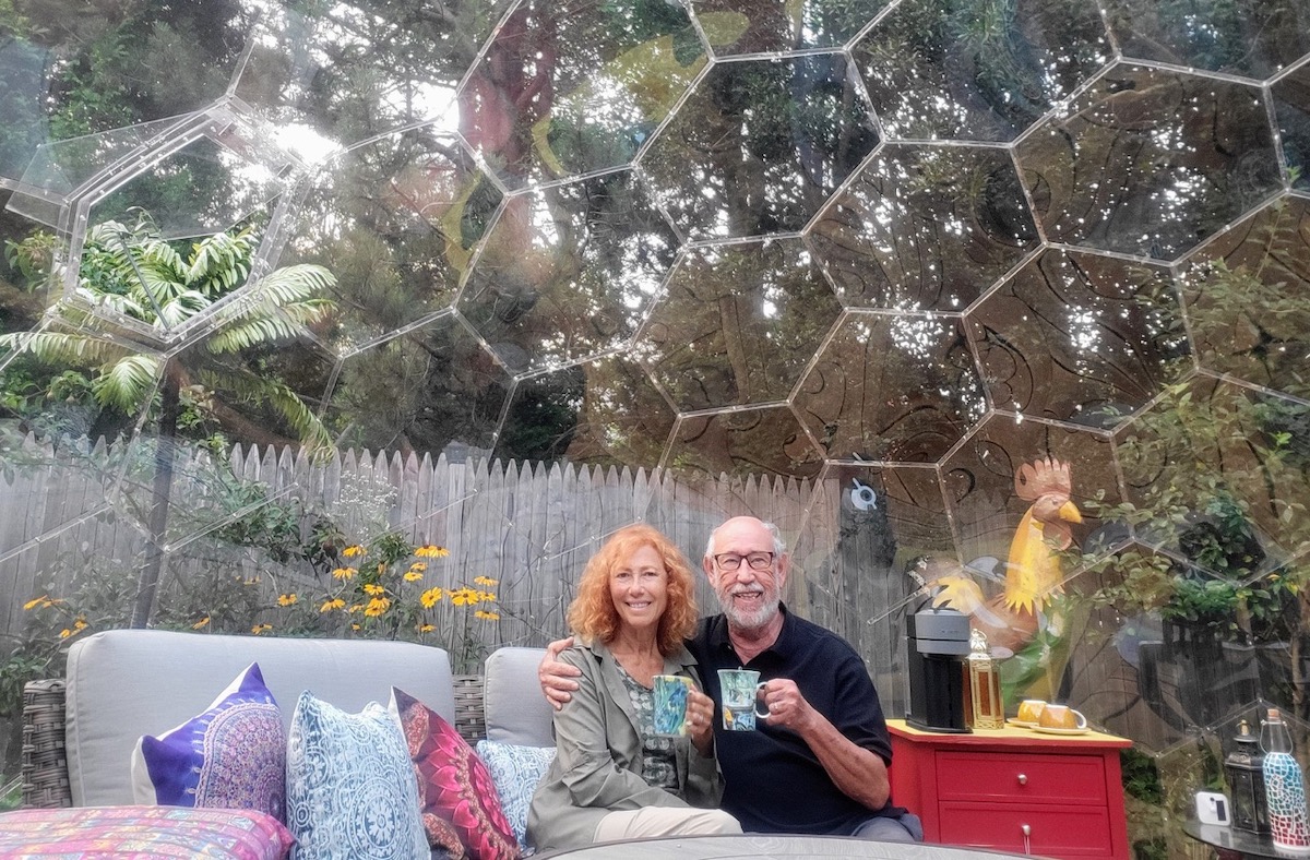 Susan and Sheldon sitting in their backyard room in Maine