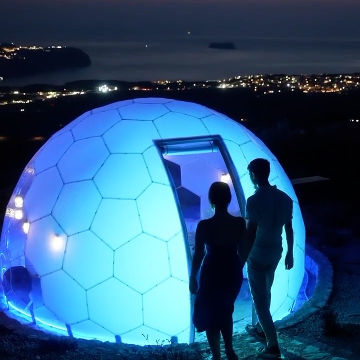 A couple entering a glowing Hypedome Opal by night